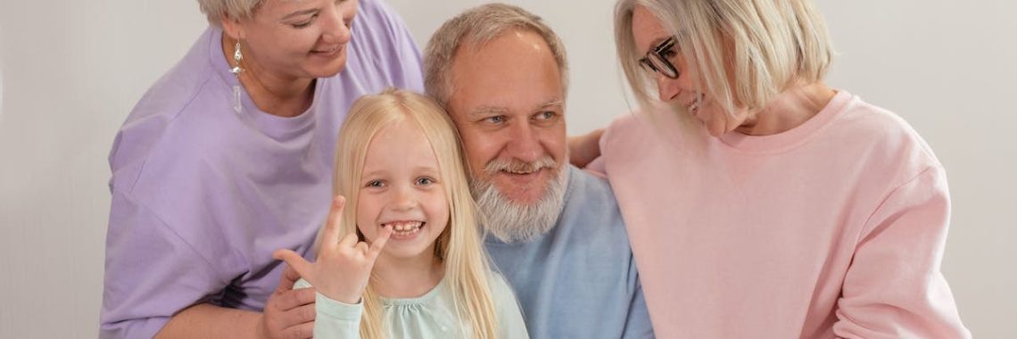A joyful multigenerational family poses and smiles together indoors, showcasing love and togetherness.